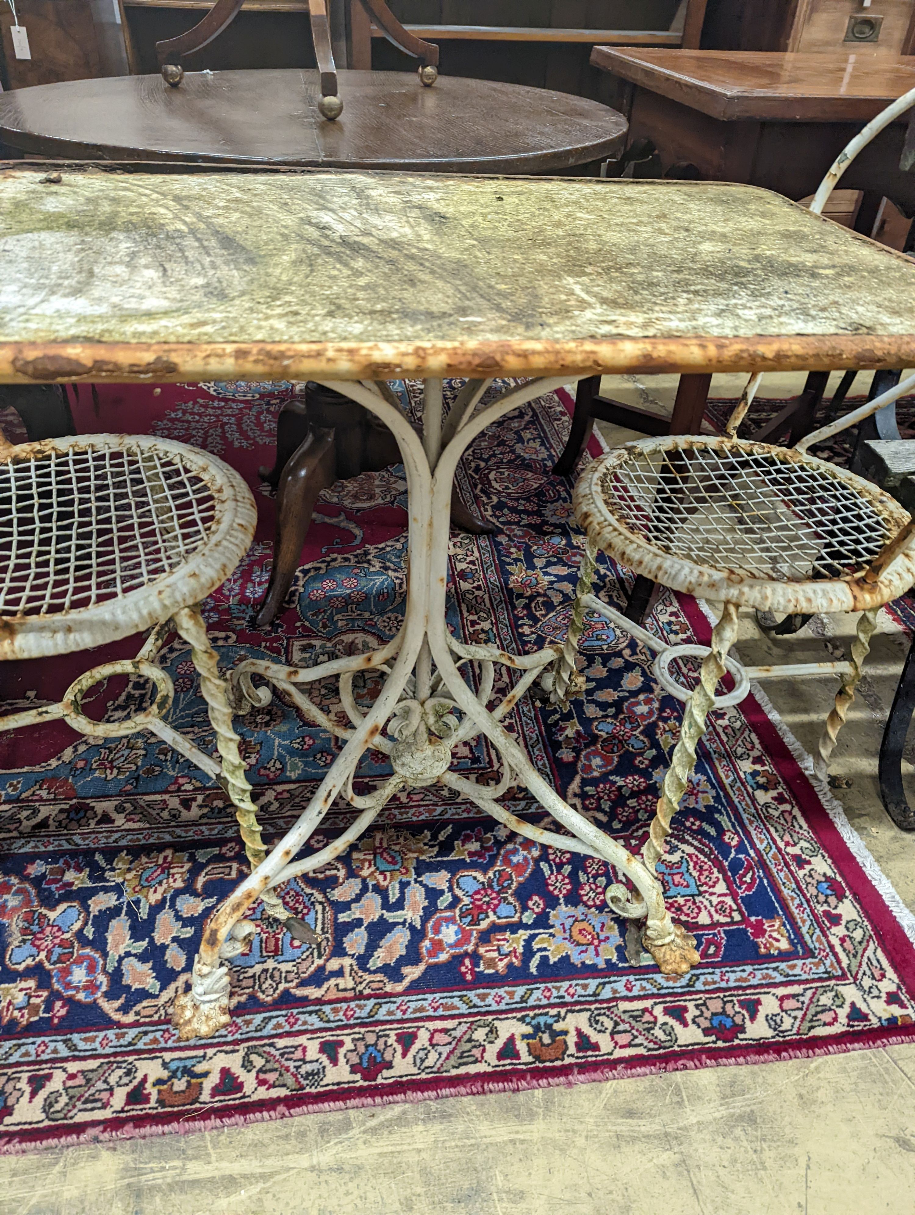 A rectangular French wrought iron garden table, length 80cm, depth 49cm, height 70cm and two chairs